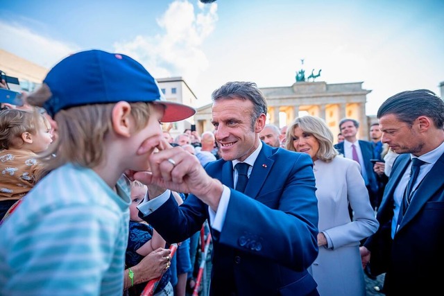 Emmanuel Macron, Prsident von Frankre...dem Brandenburger Tor durch die Menge.  | Foto: Michael Kappeler (dpa)