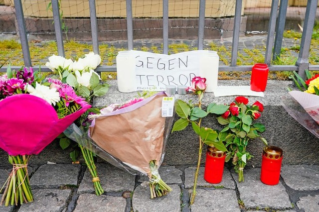 Kerzen, Blumen und ein Blatt Papier mi...Tatort auf dem Marktplatz in Mannheim.  | Foto: Uwe Anspach (dpa)
