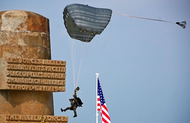 Ein Fallschirmspringer whrend der Zeremonie  am Omaha Beach  | Foto: Dirk Waem (dpa)