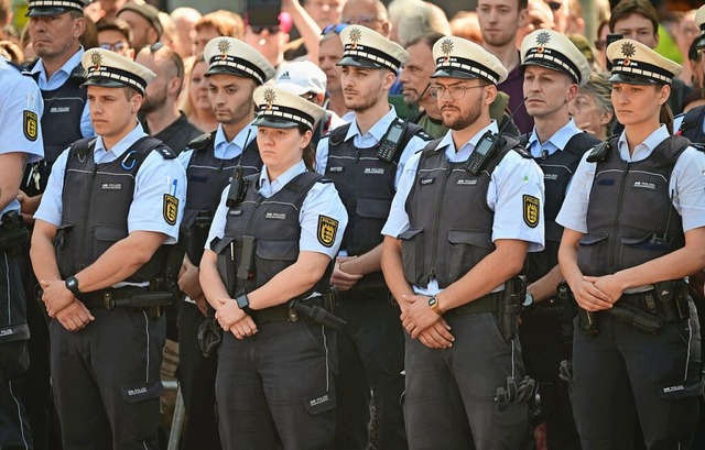 Polizisten stehen bei einer Gedenkminu...tteten Polizisten auf dem Marktplatz.  | Foto: Bernd Weibrod (dpa)