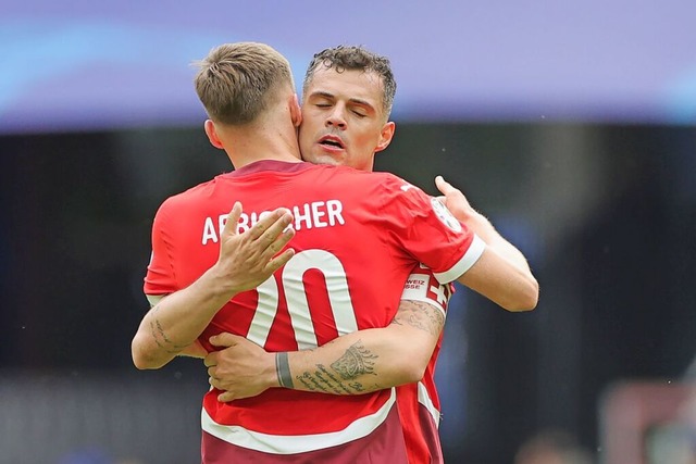 Die Schweizer Michel Aebischer (l) und Granit Xhaka umarmen sich nach dem Spiel.  | Foto: Rolf Vennenbernd (dpa)