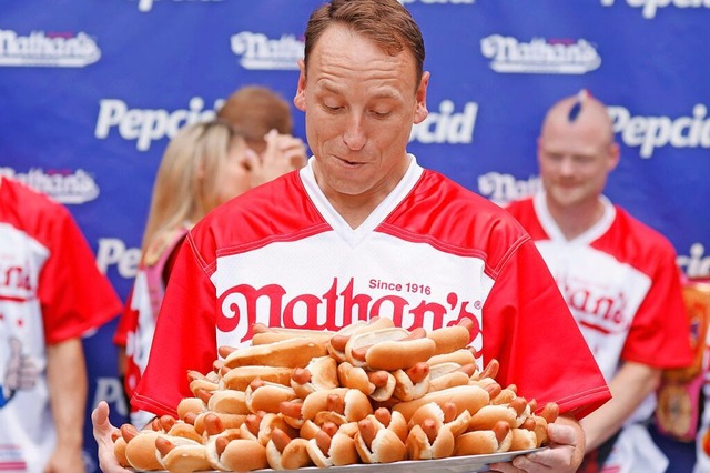 Joey Chestnut vor einem Berg Wrste  | Foto: IMAGO/JOHN ANGELILLO