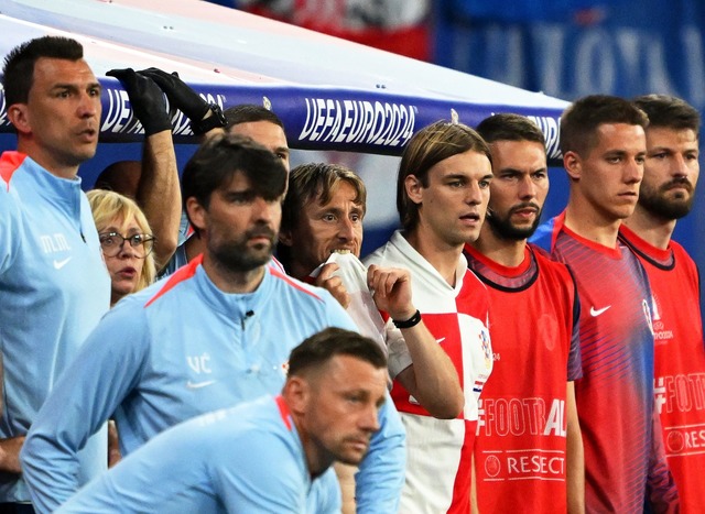 Kroatiens Luka Modric (M) und seine Teamkollegen schauen vom Spielfeldrand zu.  | Foto: Robert Michael/dpa