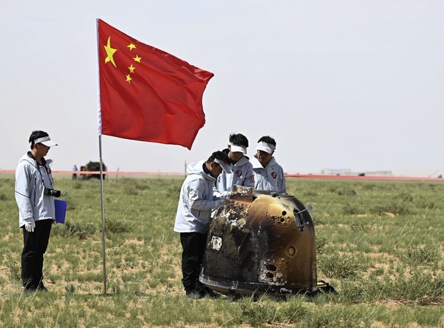 Die Flagge muss dabei sein: Die chines...el wird nach ihrer Landung inspiziert.  | Foto: Lian Zhen (dpa)