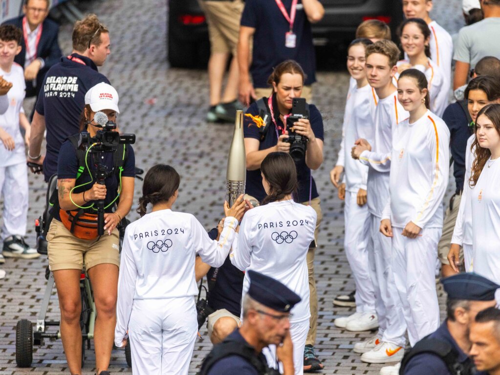 Jugendliche tragen das Olympische Feuer durch Huningue.