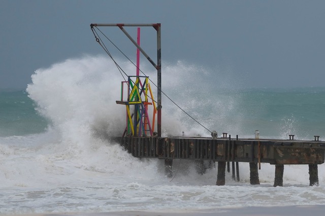 Wellen schlagen auf einen Pier, w&auml;hrend der Hurrikan "Beryl" vorbeizieht.  | Foto: Ricardo Mazalan/AP/dpa