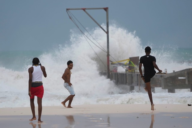Jugendliche am Strand, w&auml;hrend der Hurrikan "Beryl" durch ihre Stadt zieht.  | Foto: Ricardo Mazalan/AP/dpa