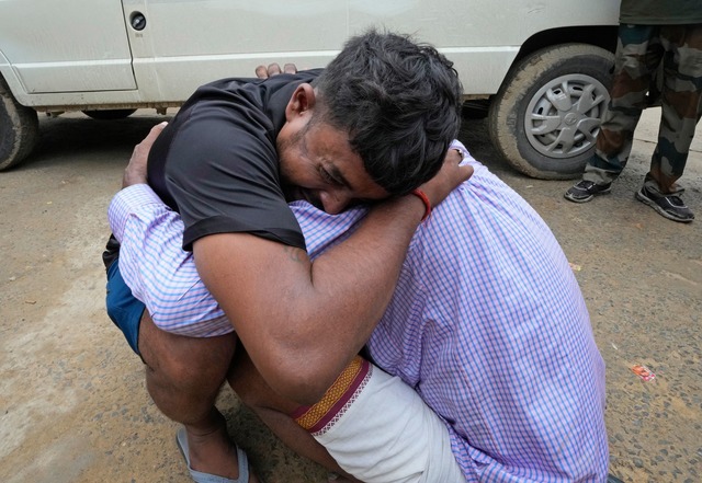 Ein Mann umarmt einen Angeh&ouml;rigen...Schwester Opfer der Massenpanik wurde.  | Foto: Rajesh Kumar Singh/AP/dpa