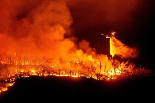 Ein Hubschrauber wirft Wasser auf das Thompson-Feuer  | Foto: Noah Berger/AP/dpa