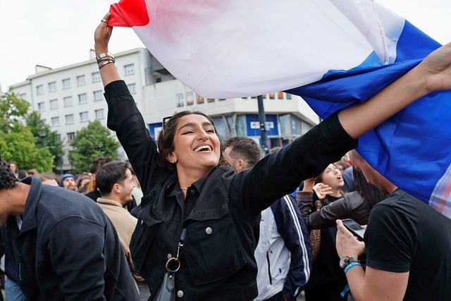 Menschen schwenken in Nantes die franz...er zweiten Runde der Parlamentswahlen.  | Foto: Jeremias Gonzalez (dpa)