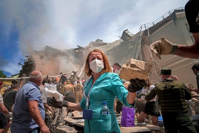 Rettungskrfte vor dem Okhmatdyt-Kinde...Kiew, das von Raketen getroffen wurde.  | Foto: Evgeniy Maloletka (dpa)