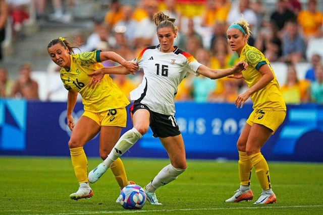 Jule Brand (Mitte) kmpft gegen Austra... Ellie Carpenter (rechts) um den Ball.  | Foto: Daniel Cole (dpa)