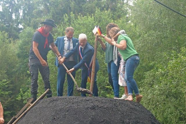 Franzosen und Deutsche setzen den Kohlenmeiler in Dachsberg gemeinsam in Glut