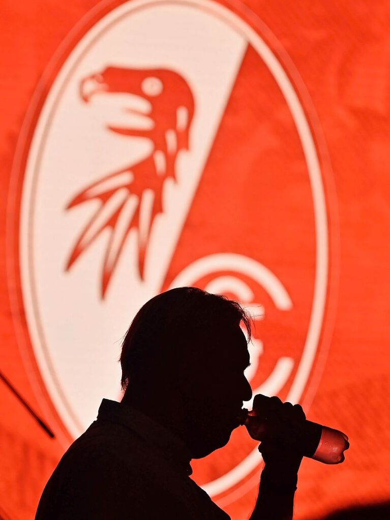 Volker Finke vor dem Logo des SC Freiburg