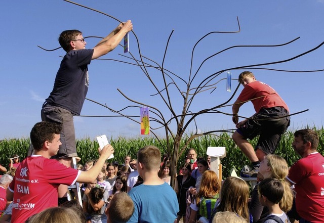 Die Kinder befestigen mit Hilfe der Betreuer ihre Wnsche an dem Glcksbaum.   | Foto: Hubert Rderer