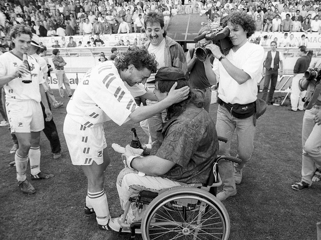 22.5.1993: Freiburg – Unterhaching 4:2: Die Freude ist gro nach diesem Spiel im Dreisamstadion: Die Spieler des Sportclubs feiern den ersten Aufstieg in die erste Bundesliga. Hier umarmt Torschtze Altin Rraklli einen Fan. Ausschlaggebend fr die Dominanz des Zweitliga-Meisters aus dem Breisgau war laut Trainer Finke auch die Taktik: Das System der Zonen und kurzen Wege: bernehmen und bergeben. Raumorientierung statt Prchenbildung.