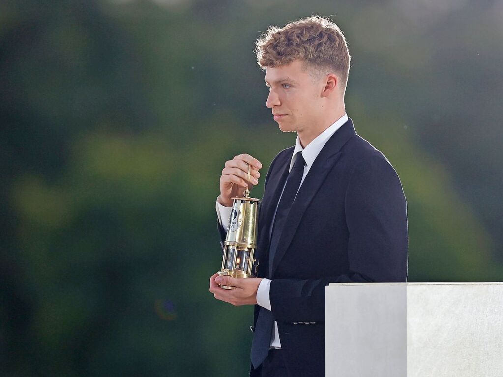 Der franzsische Schwimmer Leon Marchand war einer der Stars der Spiele in Paris. Bei der Schlussfeier trug er eine Laterne mit der olympischen Flamme im Tuileriengarten.