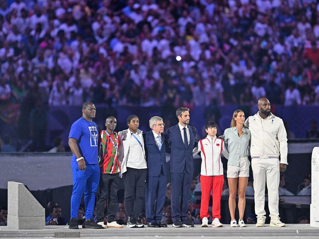 Tony Estanguet (4.vr, Prsident des Organisationskomitees fr die Olympischen und Paralympischen Spiele, und IOC-Prsident Thomas Bach (4.vl) stehen bei der Schlussfeier auf der Bhne mit Athletinnen und Athleten.