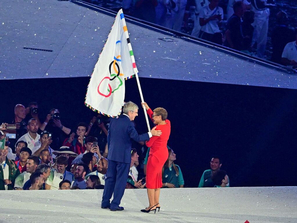 IOC-Prsident Thomas Bach bergibt Karen Bass, Brgermeisterin von Los Angeles, die olympische Fahne.