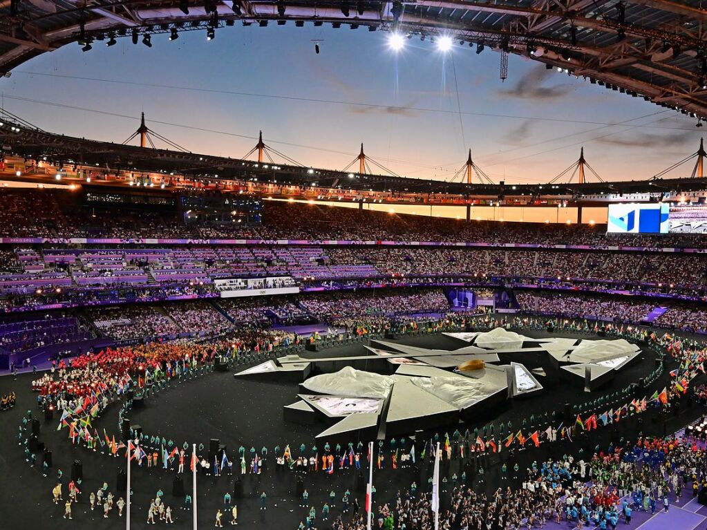 Die Athletinnen und Athleten stehen bei der Schlussfeier im Stadion.