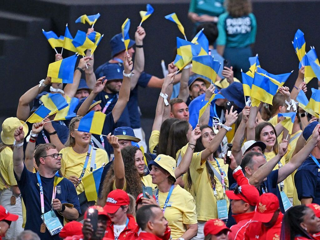 Athletinnen und Athleten aus der Ukraine stehen bei der Schlussfeier im Stadion.