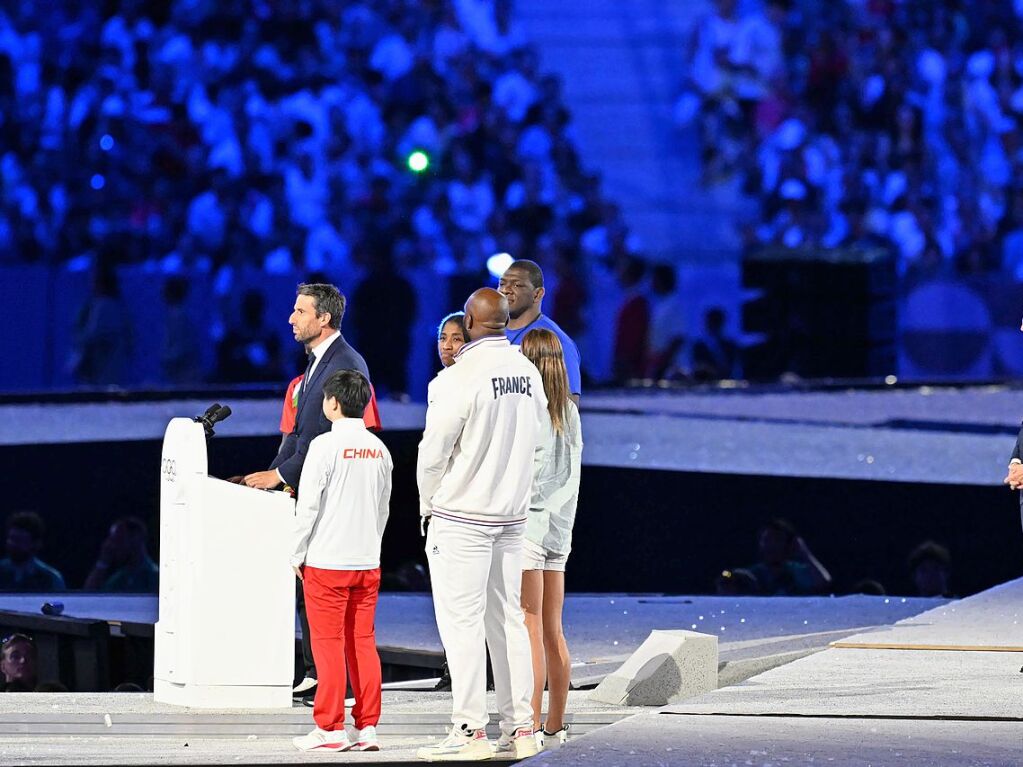 Tony Estanguet (l), Prsident des Organisationskomitees fr die Olympischen und Paralympischen Spiele, spricht bei der Schlussfeier. Rechts hrt IOC-Prsident Thomas Bach zu.