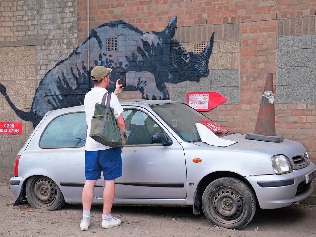 Auf der Motorhaube des Autos steht ein Verkehrskegel. Das lsst es ebenfalls ein wenig wie ein Nashorn wirken.