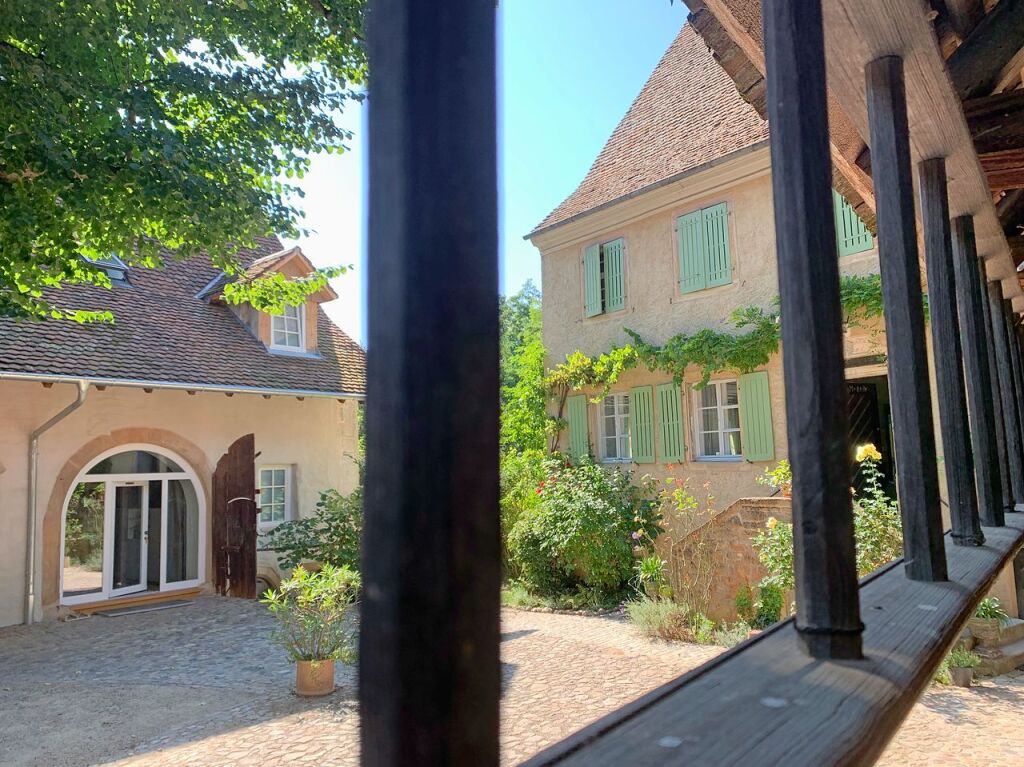 Blick in den Hof mit alter Linde: rechts das Haupthaus, links ein Teil der Scheune mit Eingang in eine der Ferienwohnungen.