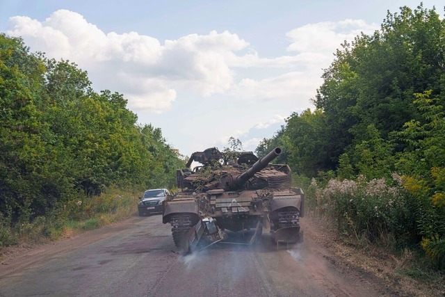 Ein beschdigter ukrainischer Panzer k...inischen Grenze in die Ukraine zurck.  | Foto: Evgeniy Maloletka (dpa)