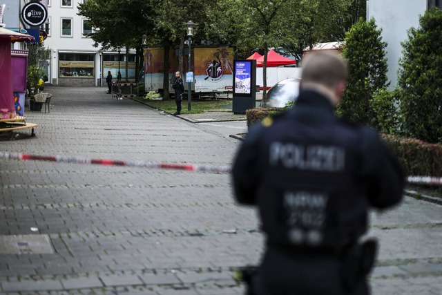 Ein Polizist steht am Morgen nach dem Angriff in der Nhe des Tatorts.  | Foto: Christoph Reichwein (dpa)