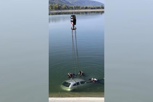 Retter bergen Auto aus Wasserbecken am Rhein