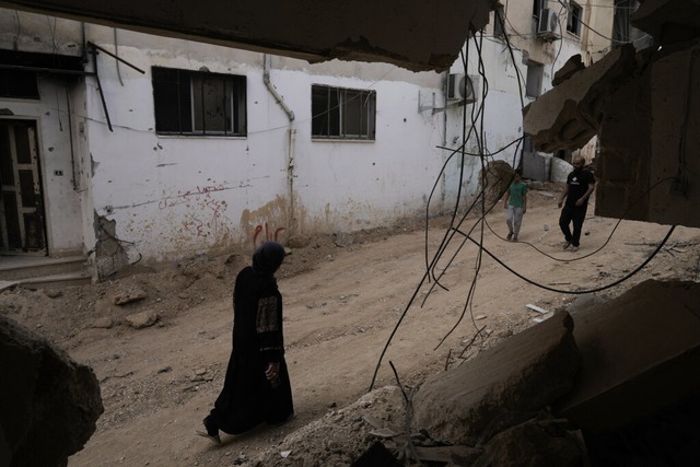 Palstinenser gehen in Dschenin nach e... an einem beschdigten Gebude vorbei.  | Foto: Majdi Mohammed (dpa)