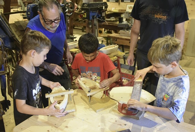 Johannes Siegel mit den Kindern beim Gltten des Bootrumpfs.  | Foto: Benedikt Sommer