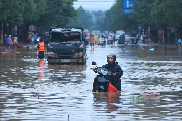 Menschen waten durch Hochwasser auf einer Strae. <Bildquelle></Bildquelle>  | Foto: VNA (dpa)