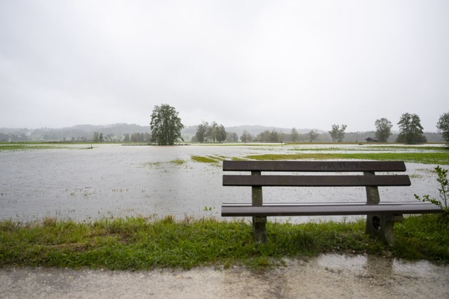 Eine Sitzbank steh vor einem berfluteten Feld in Felden am Chiemsee.  | Foto: Lennart Preiss (dpa)