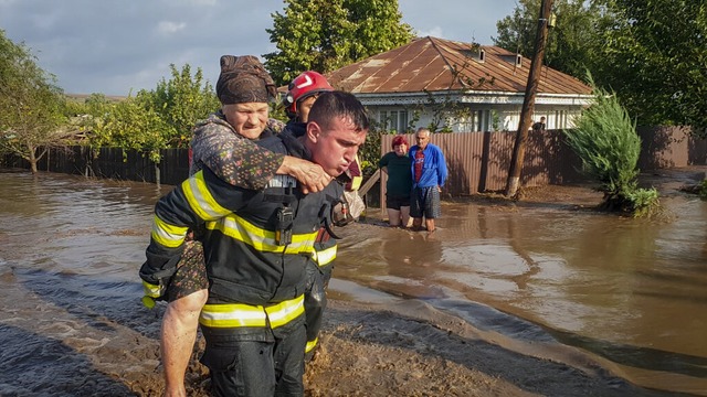 Ein Retter trgt im rumnischen Pechea...lreiche Menschen eingeschlossen haben.  | Foto: ISU Galati Romanian Emergency Sevices/AP/dpa