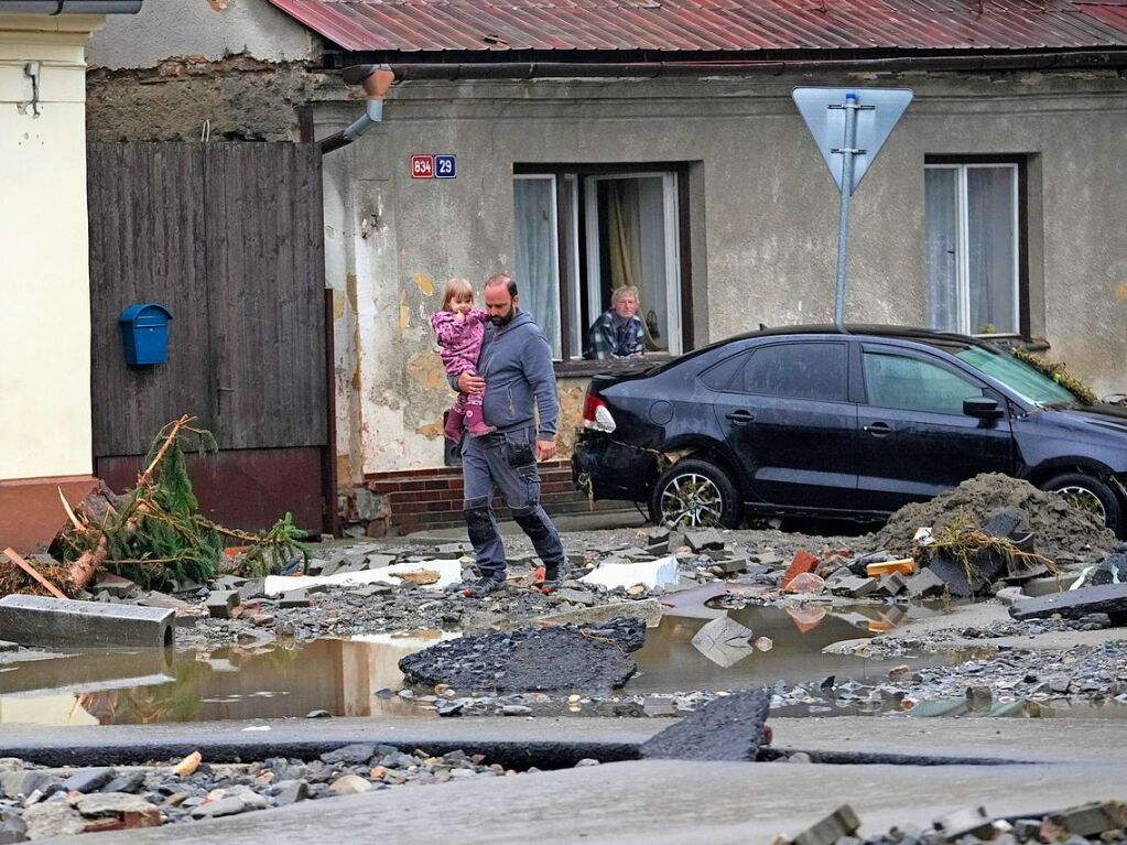 Tschechien, Jesenik: Anwohner gehen nach den berschwemmungen durch Trmmer.