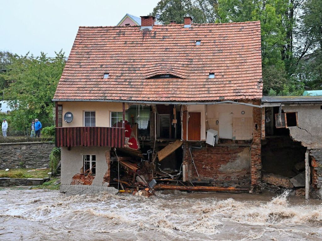 Polen, Ladek-Zdroj (Bad Landeck): Hochwasser strmt an einem Haus vorbei, bei dem ein Teil der Front weggerissen wurde.