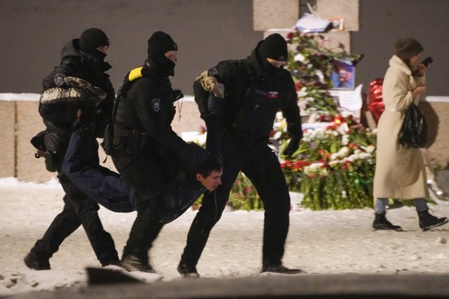 Polizeibeamte halten einen Mann fest, ...ng in St. Petersburg niedergelegt hat.  | Foto: Uncredited (dpa)