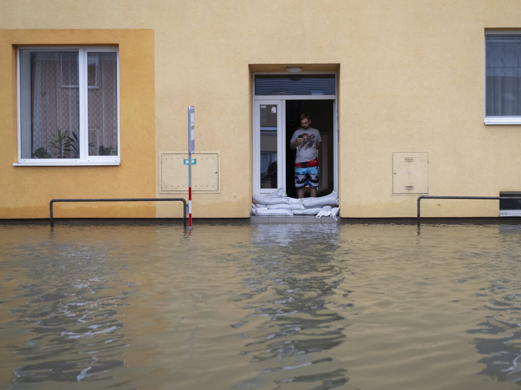 Tschechien, Litovel: Ein Mann steht vor Sandscken an einer berschwemmten Strae.