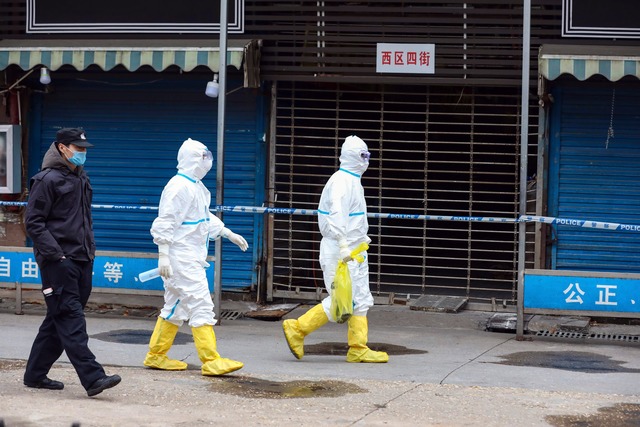 Arbeiter in Schutzkleidung tragen eine...rket entkommen sein soll. (Archivbild)  | Foto: -/CHINATOPIX/AP/dpa