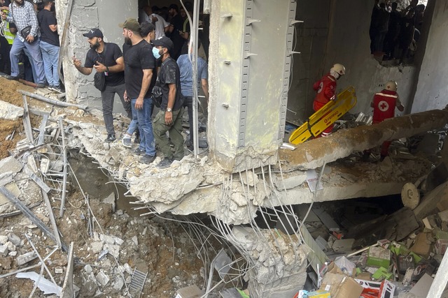 Menschen und Rettungskrfte versammeln... in den sdlichen Vororten von Beirut.  | Foto: Bilal Hussein (dpa)