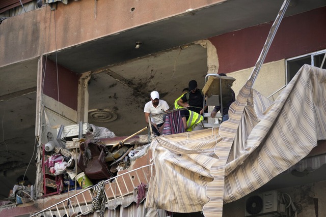 Anwohner und Rettungskrfte berprfen...roffen wurde.<Bildquelle></Bildquelle>  | Foto: Hassan Ammar (dpa)