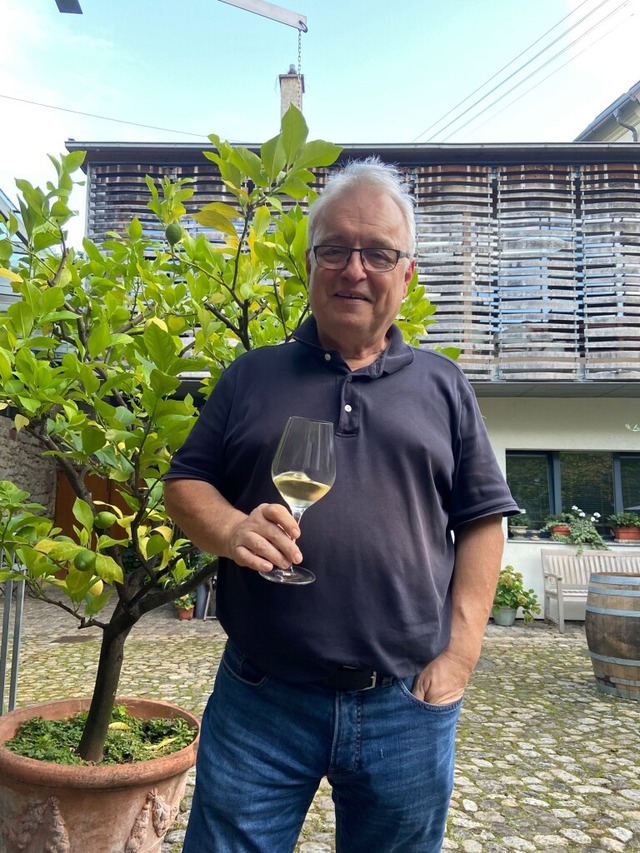 Joachim Heger mit einem Riesling aus dem Winklerberg im Hof seines Weinguts  | Foto: Klaus Riexinger