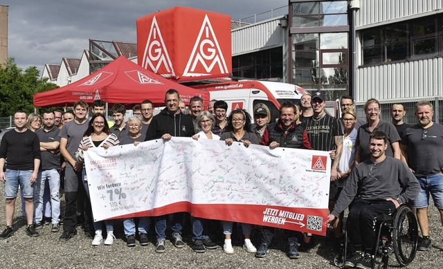 Angestellte der Firma Schneider Electric unterschrieben auf einem Banner.   | Foto: Wolfgang Knstle