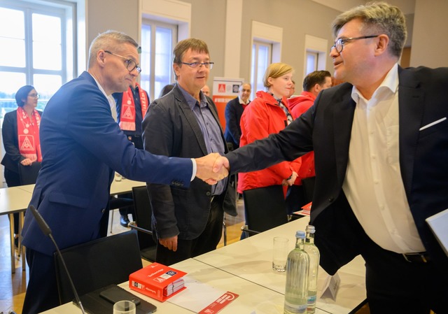 Die Verhandlungsf&uuml;hrer Thorsten G...&szlig;en sich im Saal per Handschlag.  | Foto: Julian Stratenschulte/dpa