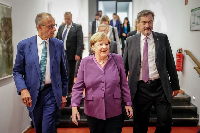 Markus S&ouml;der, CSU-Vorsitzender un...anzlerin Angela Merkel zu ihrem Platz.  | Foto: Kay Nietfeld/dpa