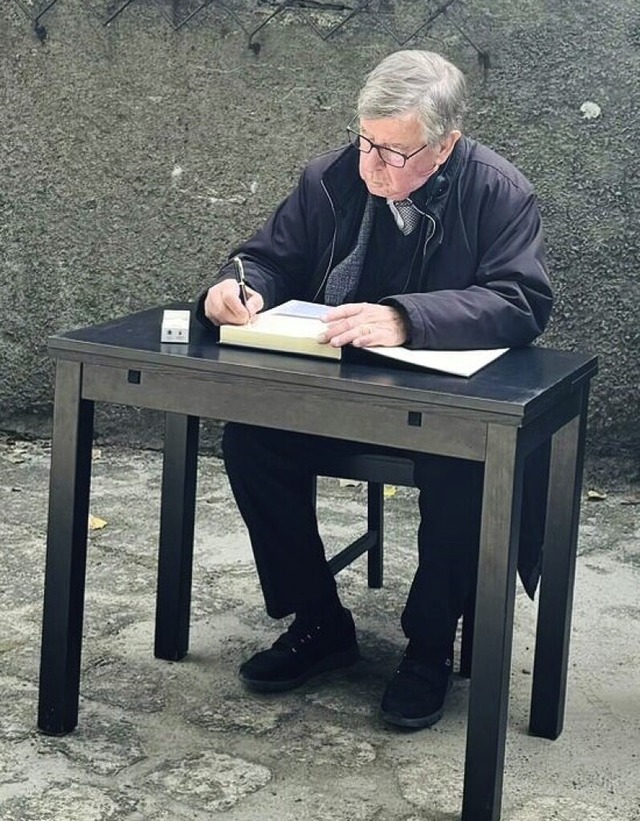 Willi Stchele trgt sich in Auschwitz ins Gedenkbuch ein.  | Foto: Jasmin Stanoschefsky <jasmin.stanoschefsky@blickwuerdig.com>