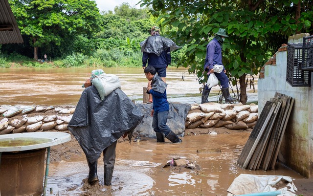 Mit Sands&auml;cken versuchten Helfer, die Fluten aufzuhalten.  | Foto: Pongmanat Tasiri/SOPA Images via ZUMA Press Wire/dpa