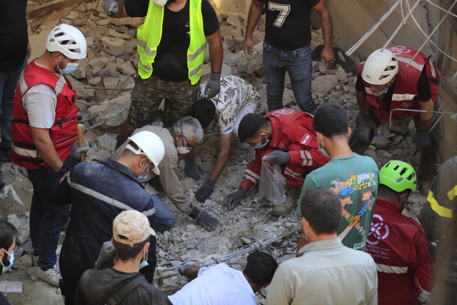 Rettungskrfte suchen nach Opfern eine... fr Vertriebene umfunktioniert wurde.  | Foto: Mohammad Zaatari (dpa)